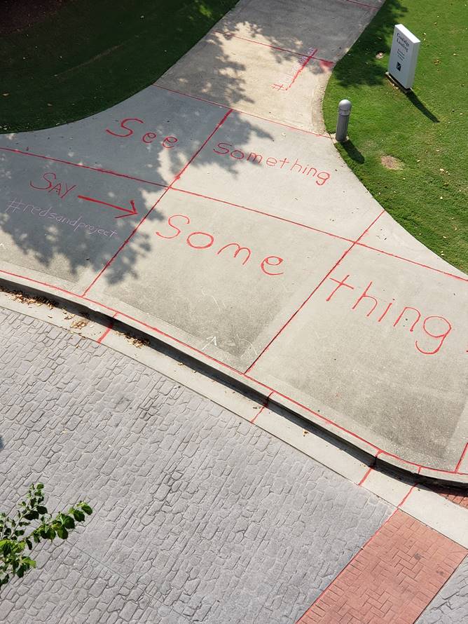 HCHD, Partners Highlight Human Trafficking with Red Sand Art Project